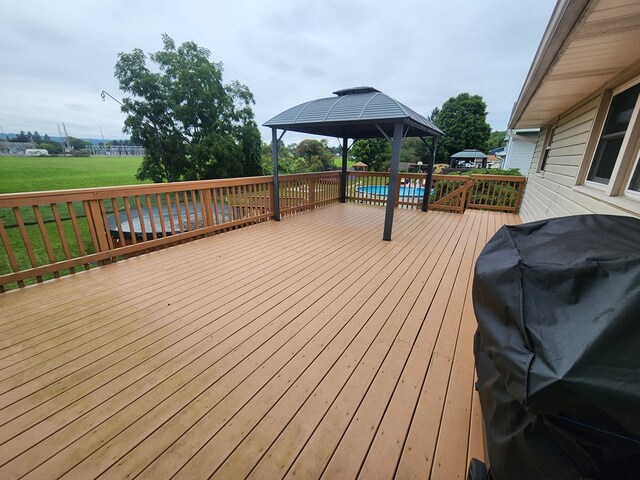 wooden deck featuring a gazebo, a lawn, and grilling area