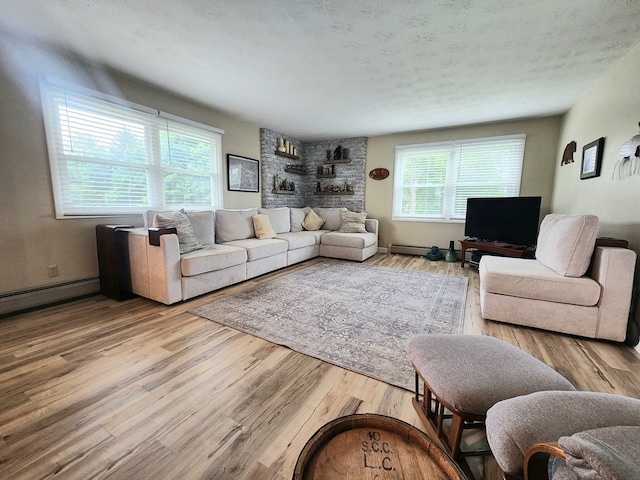 living room featuring baseboard heating, a textured ceiling, and light hardwood / wood-style flooring