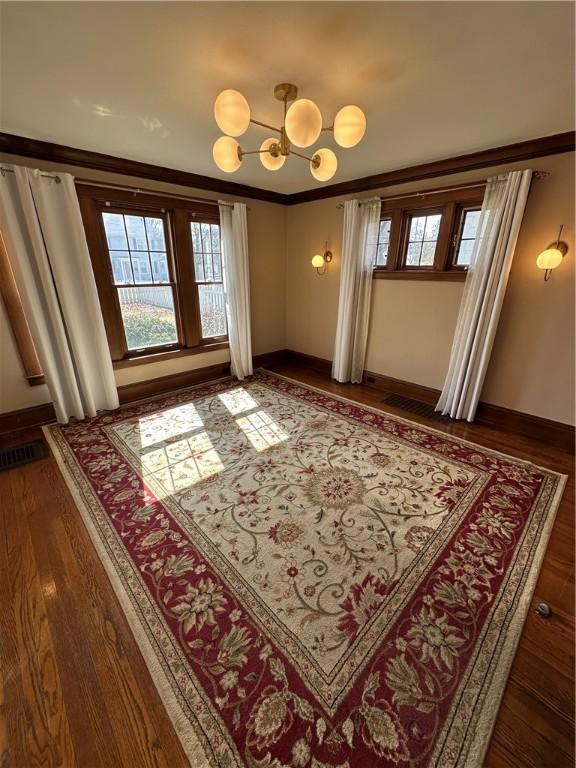 entryway featuring visible vents, ornamental molding, dark wood-type flooring, and a wealth of natural light