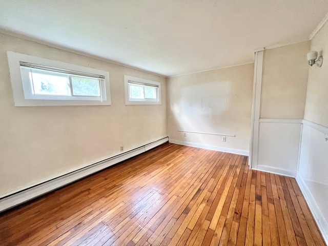 spare room featuring a baseboard radiator and light wood-type flooring