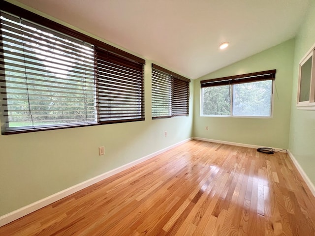 empty room with vaulted ceiling and light wood-type flooring