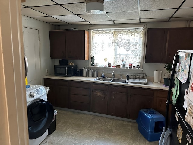 kitchen with washer / clothes dryer, dark brown cabinets, and sink