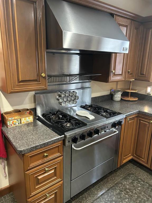 kitchen featuring wall chimney range hood and stainless steel gas stove