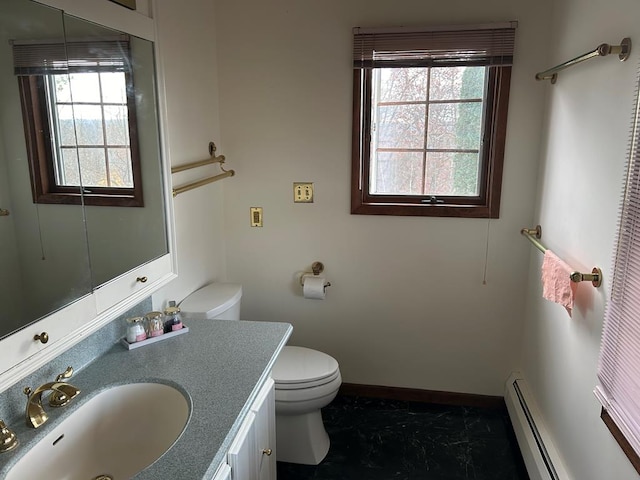 bathroom featuring toilet, vanity, a wealth of natural light, and a baseboard heating unit