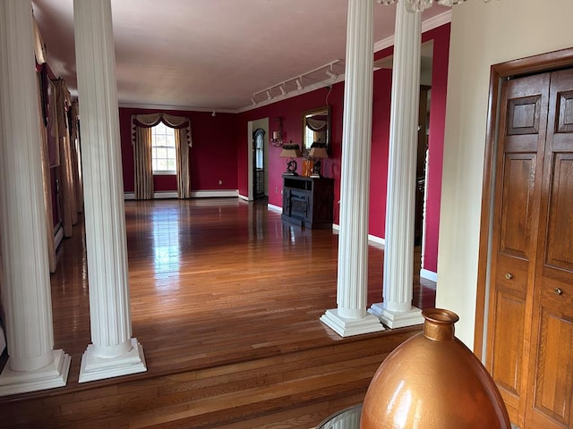 hallway with ornamental molding, dark hardwood / wood-style floors, and decorative columns