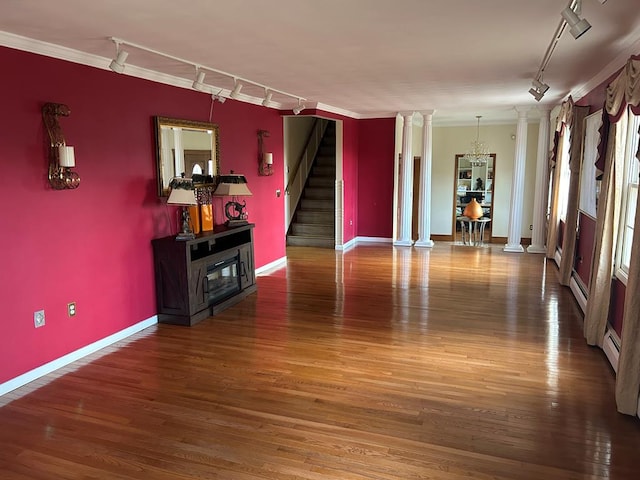 interior space featuring track lighting, dark hardwood / wood-style floors, and ornate columns