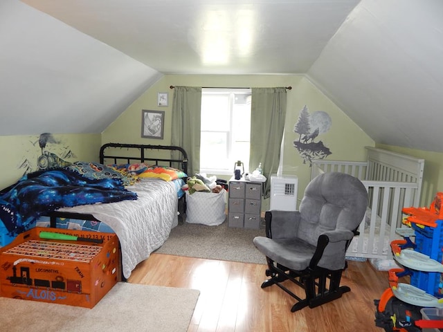 bedroom featuring vaulted ceiling and light hardwood / wood-style flooring