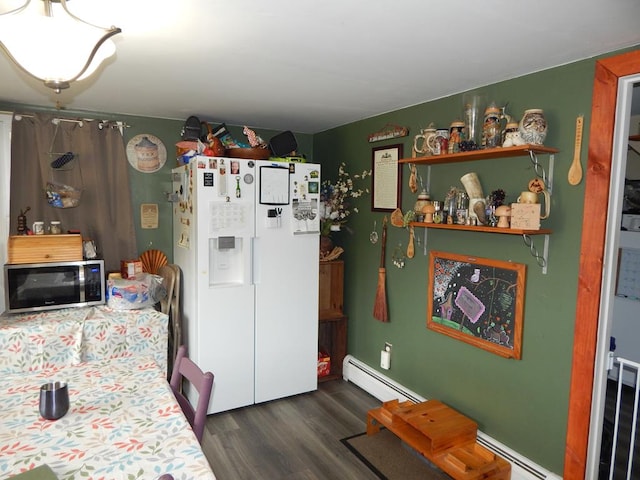 kitchen with dark wood-type flooring, a baseboard radiator, and white fridge with ice dispenser