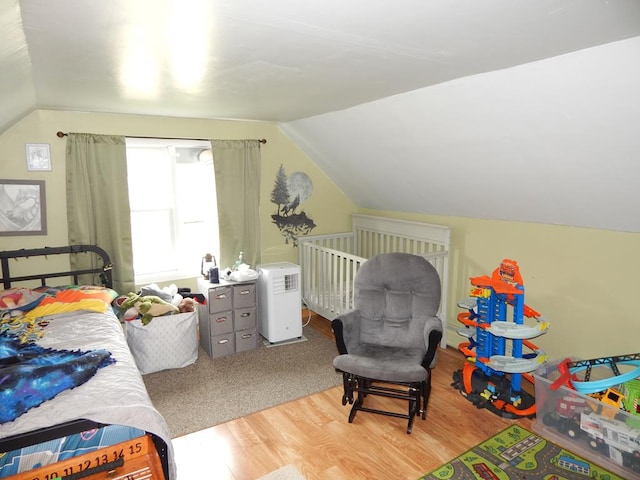 bedroom featuring vaulted ceiling and light hardwood / wood-style flooring