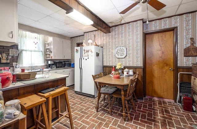 kitchen featuring a drop ceiling, ceiling fan, and white fridge