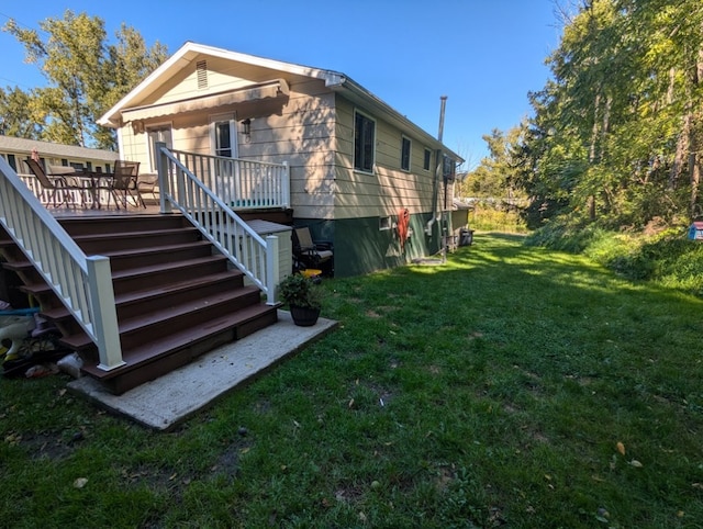 view of home's exterior with a wooden deck and a lawn