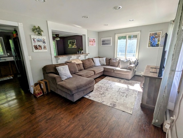 living room featuring dark wood-type flooring and baseboard heating