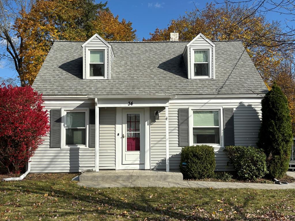 new england style home featuring a front yard