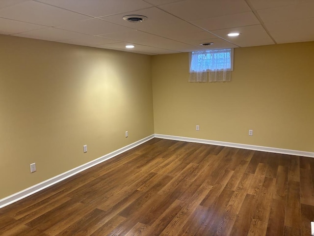 empty room with a paneled ceiling and dark hardwood / wood-style floors