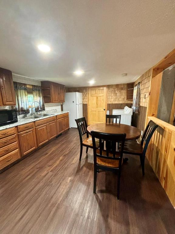 dining room with dark hardwood / wood-style flooring, sink, wooden walls, and a textured ceiling