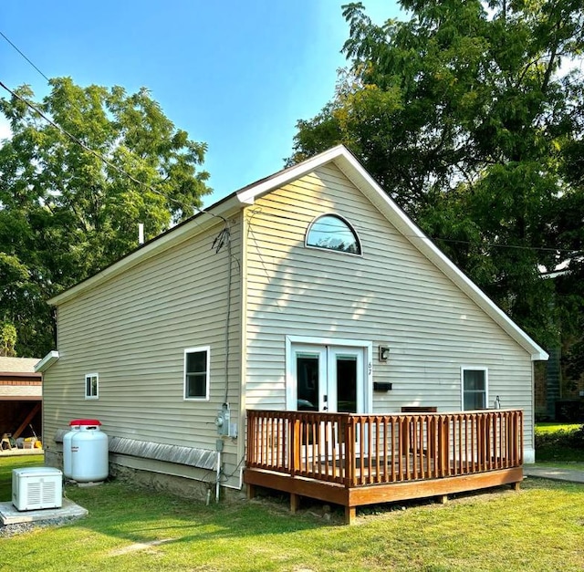 back of house featuring a wooden deck and a lawn