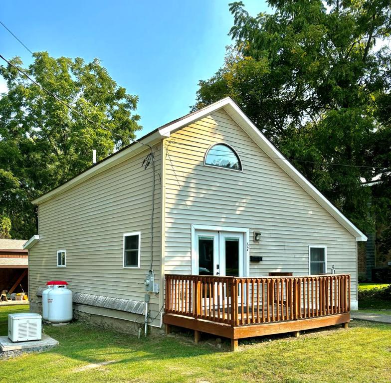 rear view of property featuring a wooden deck and a yard