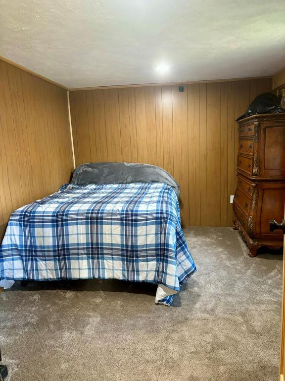 carpeted bedroom featuring wooden walls