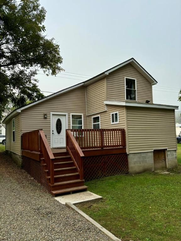 rear view of house featuring a wooden deck and a yard