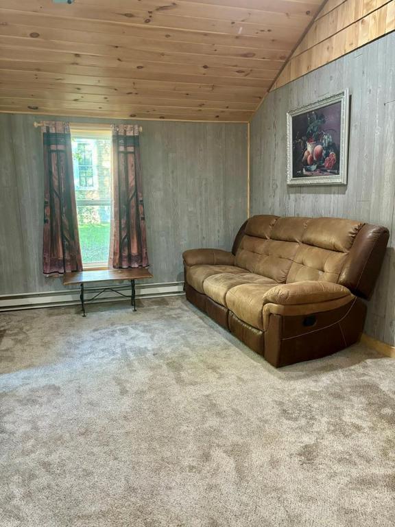 carpeted living room with lofted ceiling, a baseboard heating unit, and wooden ceiling