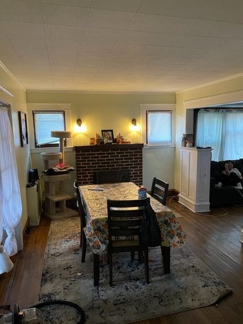 dining area with a brick fireplace, plenty of natural light, and dark hardwood / wood-style floors