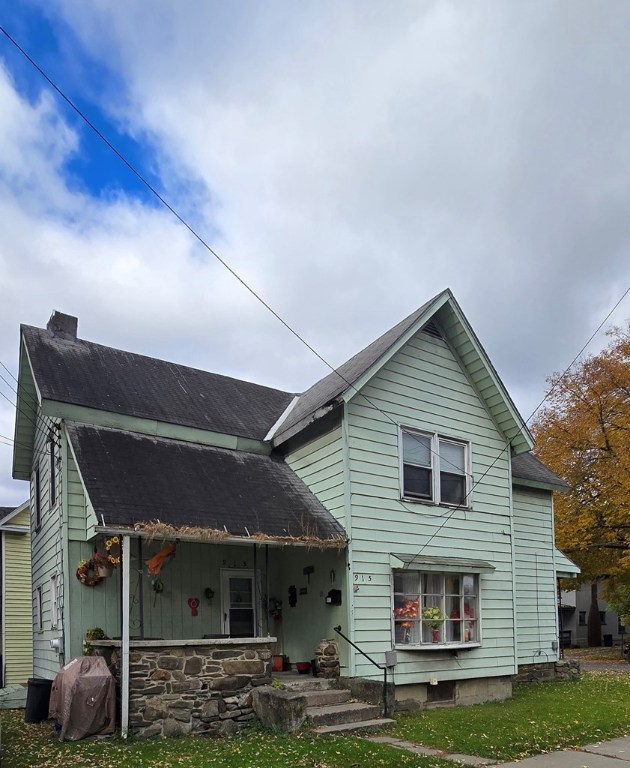 back of property with a porch and a yard