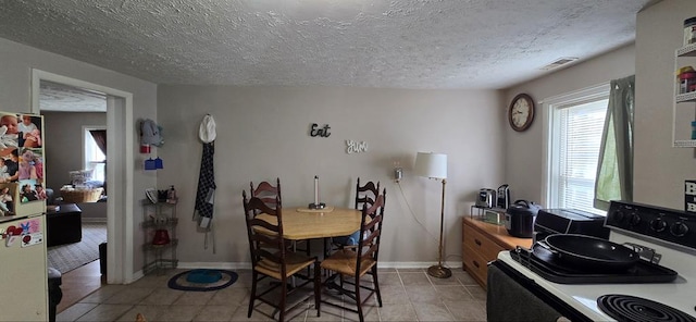 tiled dining room with a textured ceiling