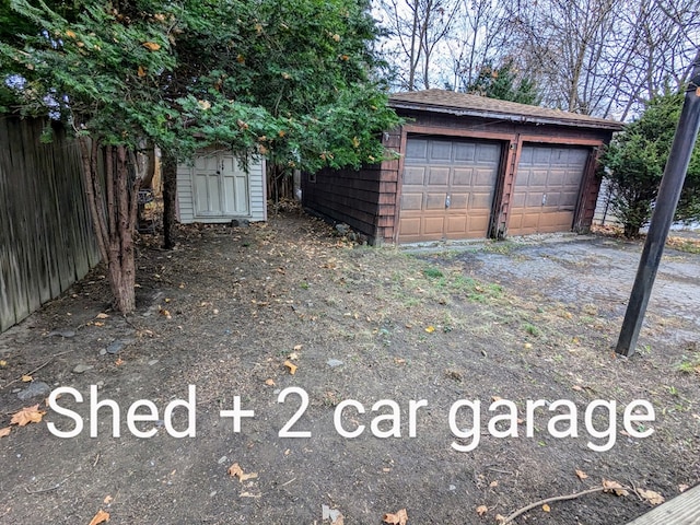 detached garage featuring fence