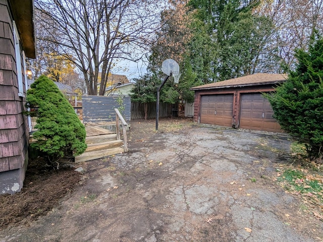 view of yard with an outbuilding, a detached garage, and fence