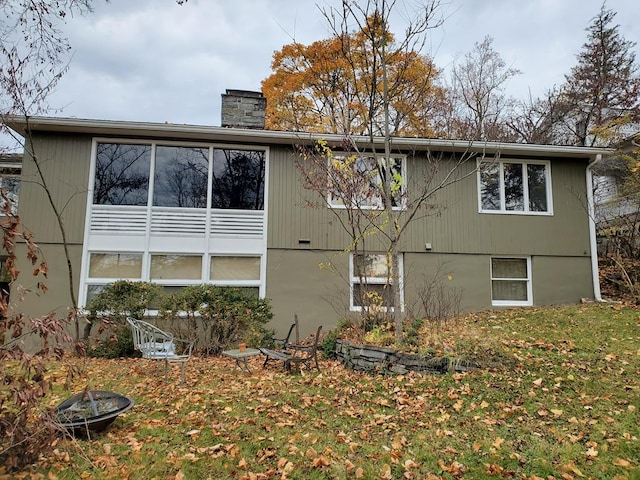 rear view of property with an outdoor fire pit