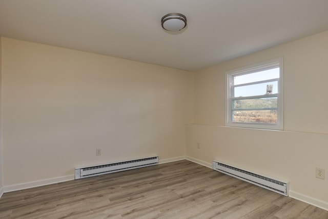 empty room with a baseboard heating unit and light hardwood / wood-style flooring