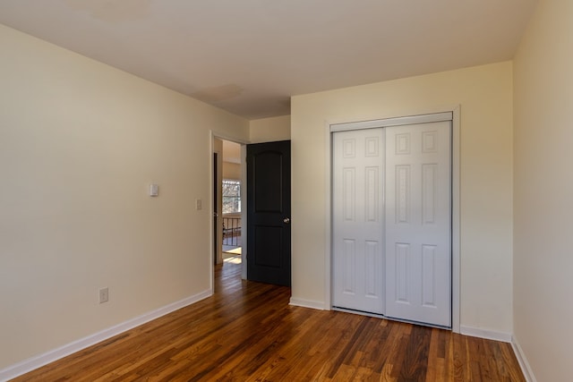 unfurnished bedroom featuring dark hardwood / wood-style flooring and a closet