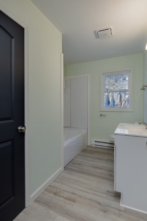 bathroom with vanity, hardwood / wood-style floors, and baseboard heating