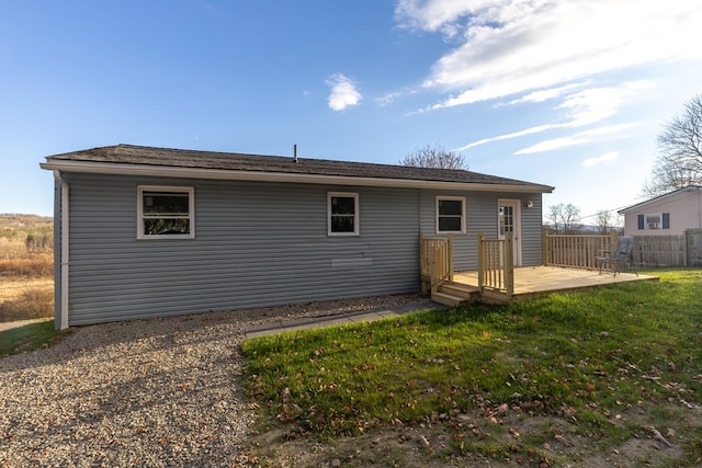 back of property featuring a wooden deck and a yard