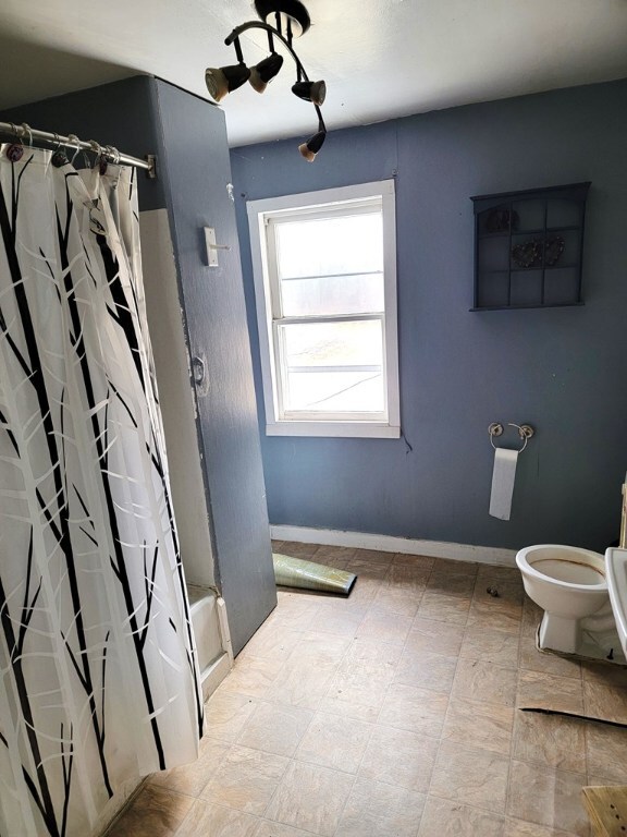 bathroom with toilet and shower / tub combo