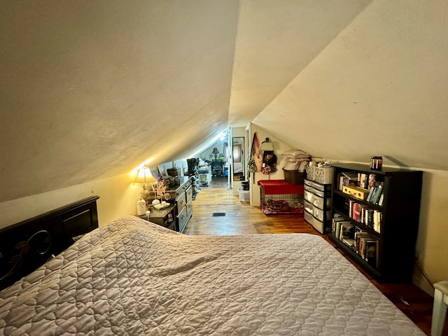 bedroom featuring hardwood / wood-style flooring and vaulted ceiling