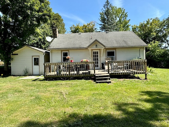 rear view of property with a wooden deck and a lawn