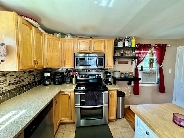 kitchen with backsplash, light tile patterned floors, and stainless steel appliances