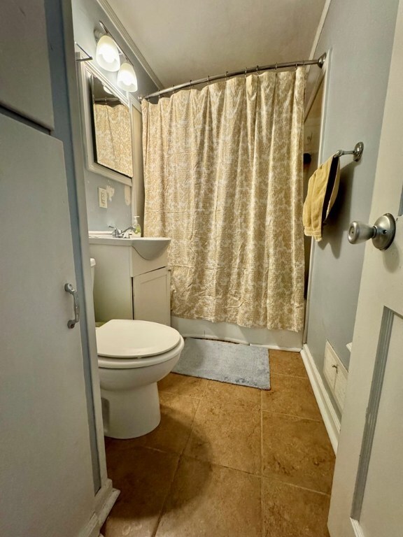 full bathroom featuring ornamental molding, vanity, toilet, and shower / bath combo with shower curtain