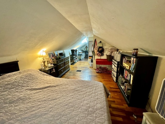 bedroom featuring lofted ceiling, hardwood / wood-style flooring, and a textured ceiling