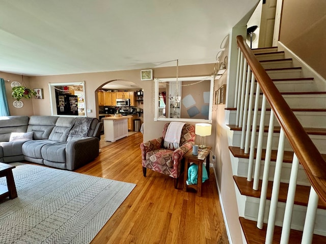 living room with an inviting chandelier and light hardwood / wood-style flooring