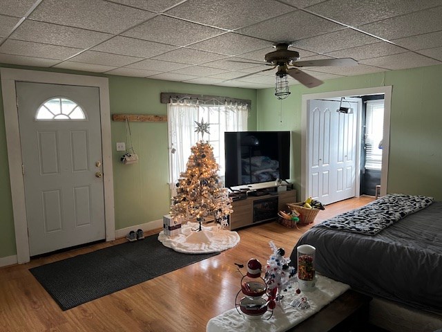 living room with wood-type flooring, ceiling fan, and a paneled ceiling