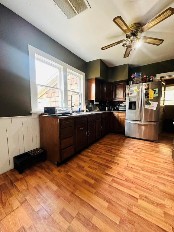 kitchen featuring sink, ceiling fan, light hardwood / wood-style floors, stainless steel refrigerator with ice dispenser, and dark brown cabinets