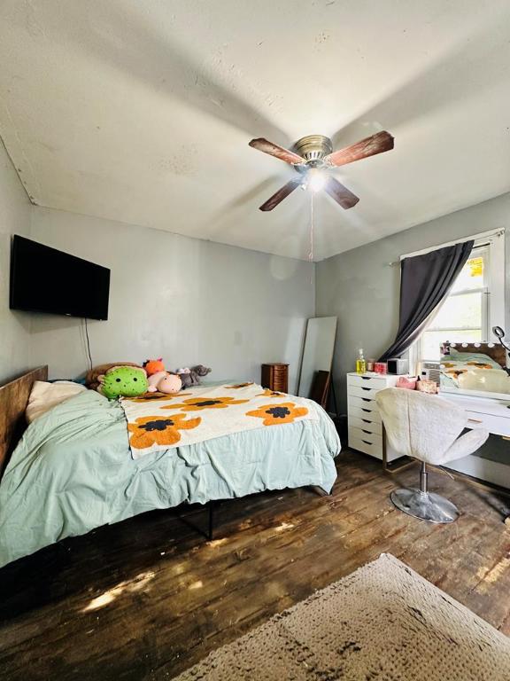 bedroom with wood-type flooring and ceiling fan