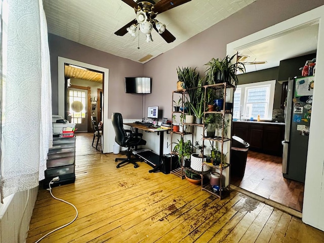 office space with plenty of natural light, hardwood / wood-style floors, and ceiling fan