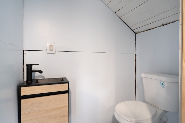 bathroom featuring vanity, vaulted ceiling, and toilet