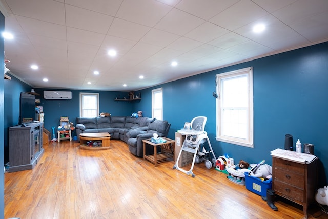 living room featuring crown molding, a wall mounted air conditioner, and light hardwood / wood-style floors