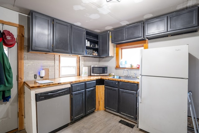 kitchen with sink, light wood-type flooring, and appliances with stainless steel finishes