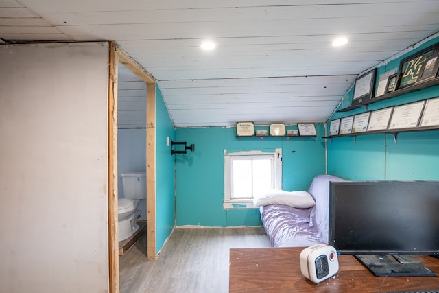 bedroom featuring wood-type flooring and vaulted ceiling