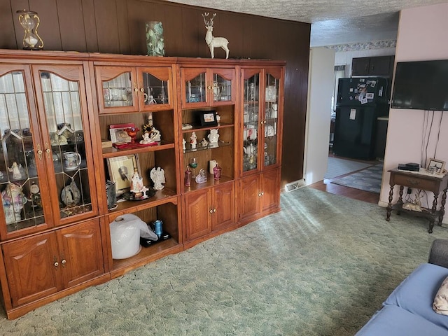 interior space featuring black refrigerator and carpet flooring